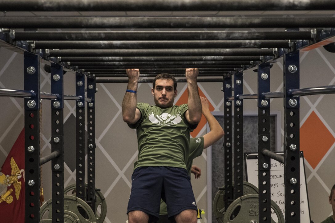 A Marine poolee executes his 11 pull-ups for his current circuit during the MacDonald Hero Workout event at Iron Empire gym in Dover, New Hampshire, Nov. 10, 2015. Iron Empire hosted a community workout in honor Lance Cpl. MacDonald, a Marine who lost his life in Iraq in 2003, or whomever the participants individually wanted to honor.