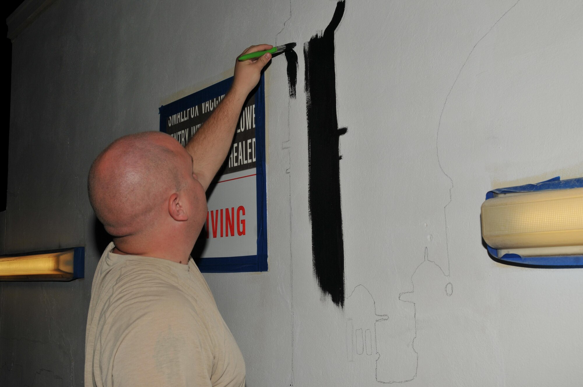 Staff Sgt. Jesse Shepard, 379th Expeditionary Operations Support Squadron, came out to paint the coalition compound interior pool walls Nov. 14 at Al Udeid Air Base, Qatar. Shepard said he wanted to contribute outside his work center. The theme for the pool mural is “a desert oasis.” (U.S. Air Force photo by Tech. Sgt. Terrica Y. Jones/Released)