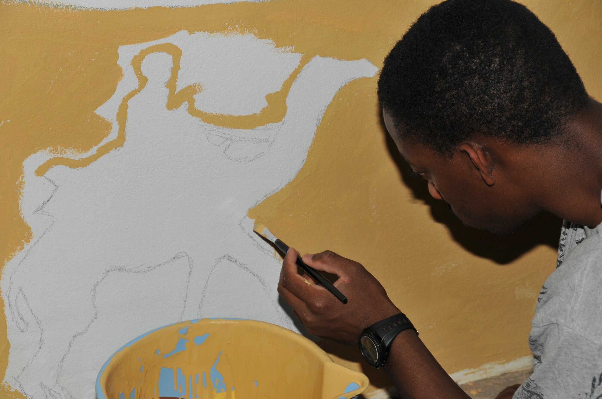 Senior Airman Alexander Buchanan, 37th Expeditionary Bomb Squadron, assisted with painting the interior pool walls in coalition compound Nov. 14 at Al Udeid Air Base, Qatar. A routine volunteer Buchanan said he is always looking for a new art project. (U.S. Air Force photo by Tech. Sgt. Terrica Y. Jones/Released)