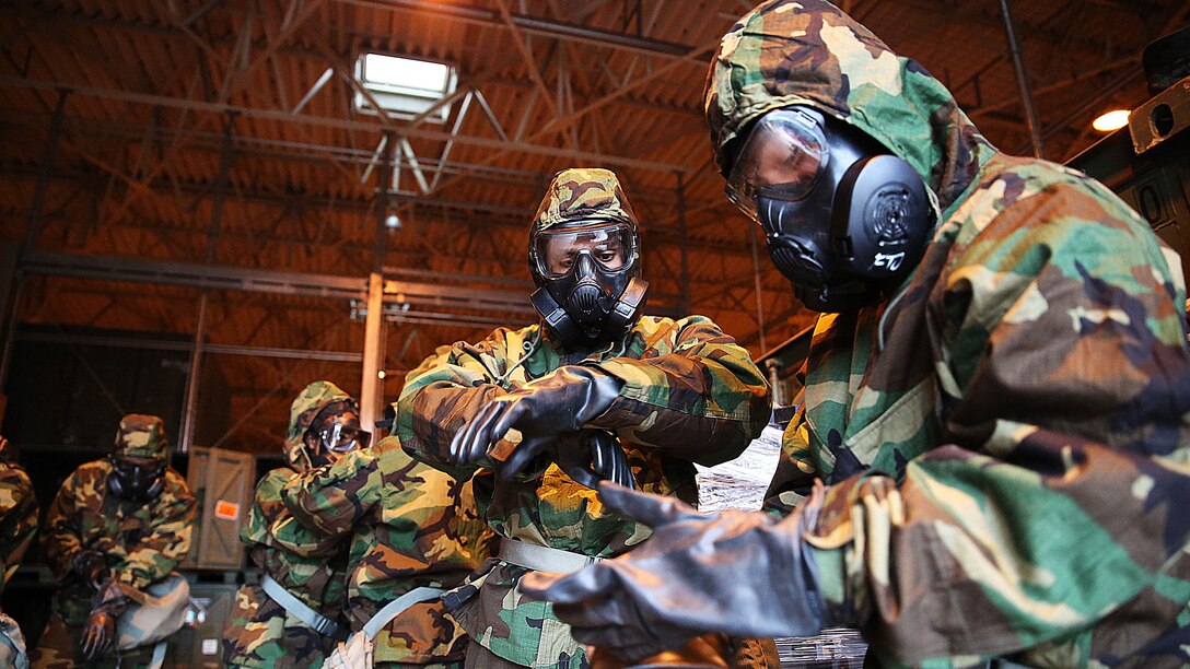 Reconnaissance, surveillance and decontamination Marines don mission-oriented protective postures four gear during a simulated chemical attack at the Marine Wing Support Squadron 171 motor transportation at Marine Corps Air Station Iwakuni, Japan, Nov. 18, 2015. As part of an operational decontamination exercise, this is just a glimpse of MWSS-171s annual unit level chemical, biological, radiological and nuclear defense training that enables combat proactivity and readiness.