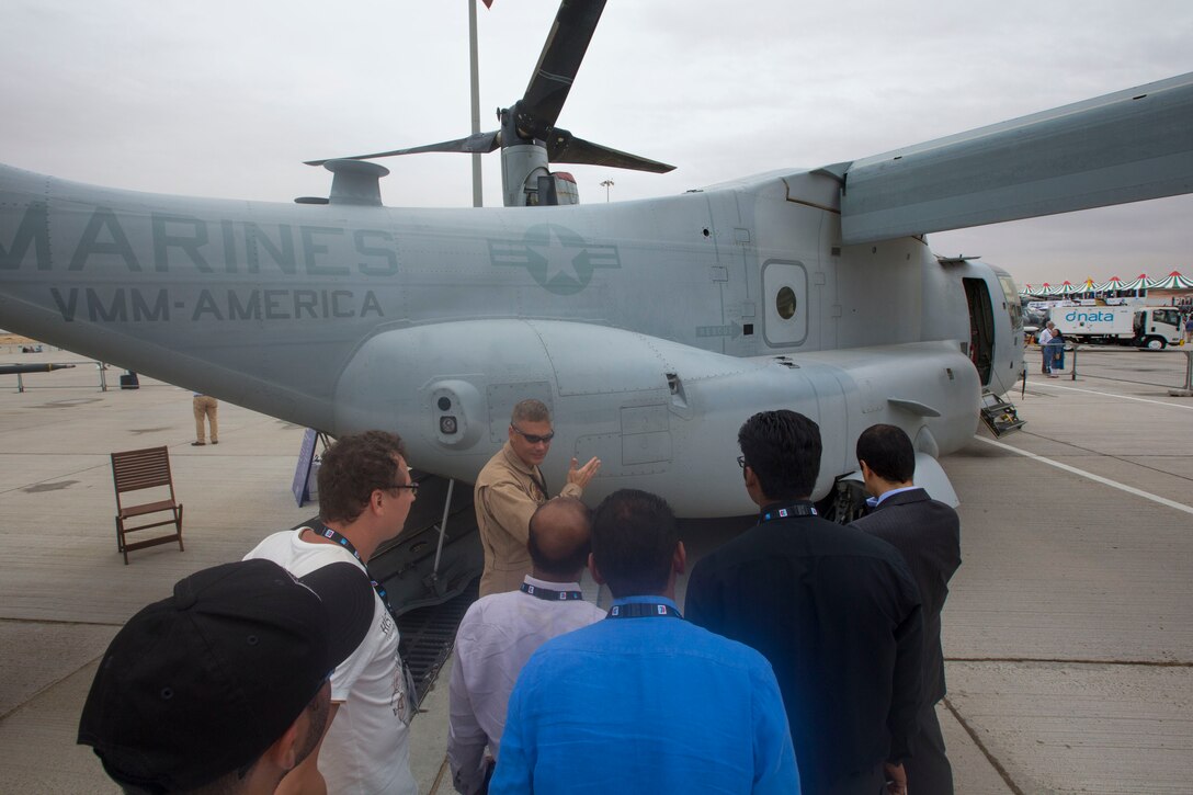 Maj. Tim Costello, a pilot and executive officer with with the Red Dragons of Marine Medium Tiltrotor Squadron 268, Aviation Combat Element, Special Purpose Marine Air-Ground Task Force Crisis Response Central Command 16.1  reviews some of the unit's aviation capabilities with a group of visitors at the 2015 Dubai Air Show, Dubai World Central, United Arab Emirates from November 8 - 12.