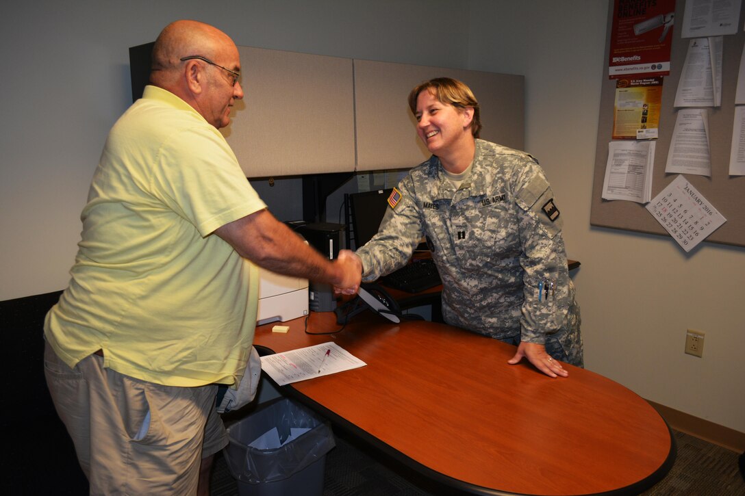 Carl Barnes, a former sergeant who served seven years in the Army Signal Corps, thanks Capt. Tanya Mayes, a military justice and admin law attorney, assigned to the 80th Training Command Office of the Staff Judge Advocate, for the legal assistance she provided to him at Hunter Holmes McGuire VA Medical Center, Richmond, Va. Staff members of the 80th TC OSJA volunteer their services once a month at the medical center helping Wounded Warriors and veterans who qualify for legal benefits. Mayes lead an effort to establish the clinic after her husband, Raymond Pacheco, a nurse at the medical center, told her that a significant number of his patients needed legal assistance.