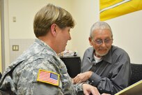 Capt. Tanya Mayes, a military justice and admin law attorney, assigned to the 80th Training Command Office of the Staff Judge Advocate, provides legal assistance to Michael Jackson, who prefers to be called Wolf, at Hunter Holmes McGuire VA Medical Center, Richmond, Va. Staff members of the 80th TC OSJA volunteer their services once a month at the medical center helping Wounded Warriors and veterans who qualify for legal benefits. Mayes lead an effort to establish the clinic after her husband, Raymond Pacheco, a nurse at the medical center, told her that a significant number of his patients needed legal assistance.