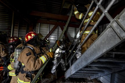 502nd Civil Engineer Squadron and Bexar County firefighters advance a hose line up a flight of stairs Nov. 17, 2015, at Joint Base San Antonio-Fort Sam Houston, Texas. Firefighters from JBSA-Randolph, Lackland, Fort Sam Houston and Bexar County combined to review basic firefighting techniques including ladder rescue, emergency medicine, search and rescue and how to quickly suppress and extinguish a house fire. (U.S. Air Force photo by Airman 1st Class Stormy Archer/Released)