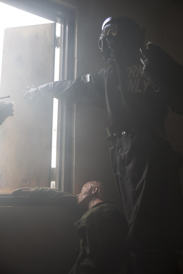 Lance Cpl. Eric D. Gore, chemical, biological, radiological and nuclear defense training NCO with Headquarters Battalion, Marine Forces Reserve, opens a window to vent simulated anhydrous ammonia gas after discovering a casualty during a CBRN training event at Camp Shelby, Miss., Nov. 17, 2015. As part of a CBRN reconnaissance team, Marines must document the hazardous environment and search for the location of any casualties. (U.S. Marine Corps photo by Cpl. Ian Leones/Released)