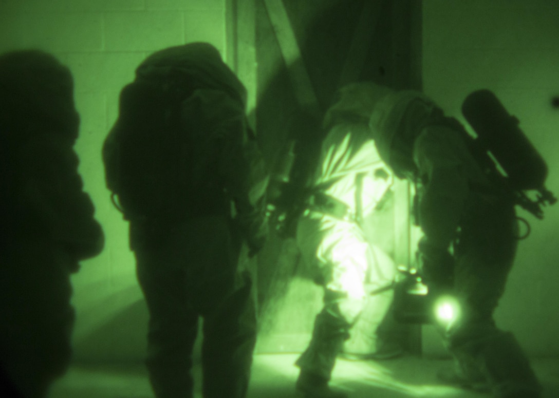 Members of a casualty recovery team breach a door to a room full of casualties surrounded by chlorine gas during a low-light training scenario at Camp Shelby, Miss., Nov. 17, 2015. Marines from across Marine Forces Reserve conducted CBRN training scenarios as part of a week-long Advanced Consequence Management course. (U.S. Marine Corps photo by Cpl. Ian Leones/Released)