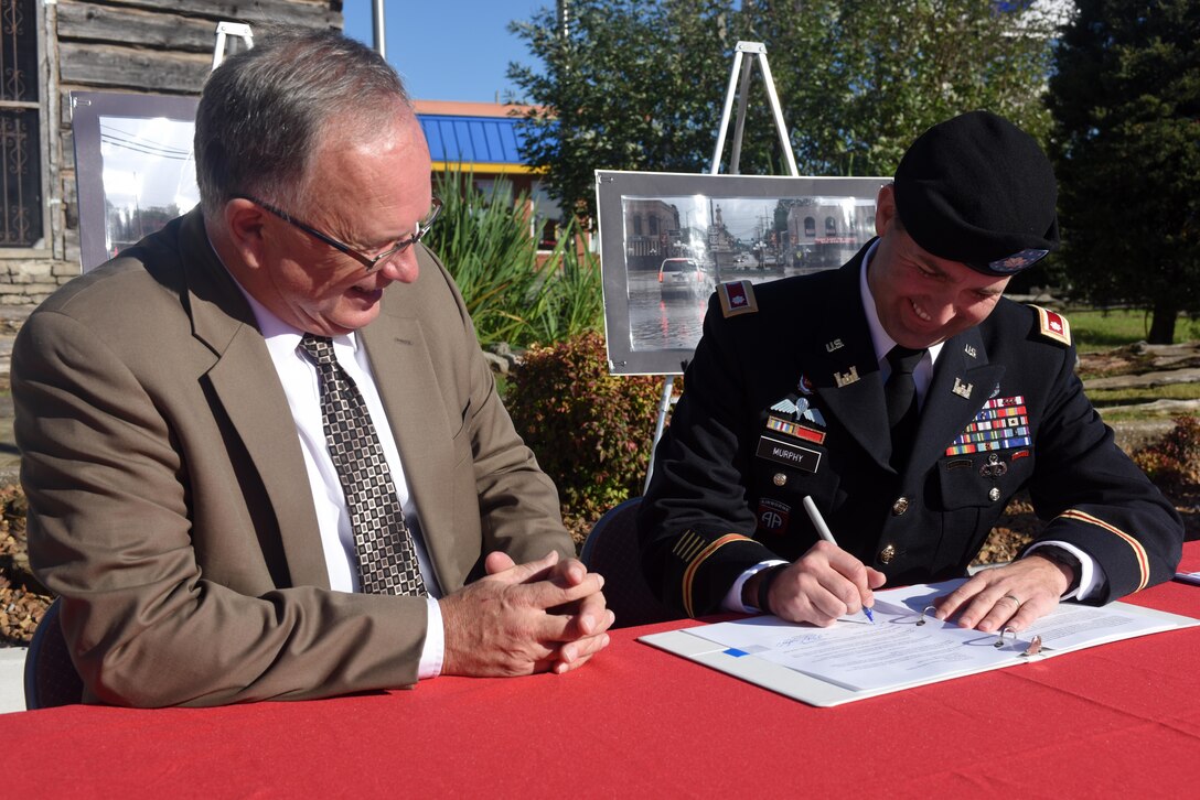 Lt. Col. Stephen Murphy (Right), U.S. Army Corps of Engineers Nashville District commander, signs an agreement with Mayor Philip Craighead, Lebanon, Tenn., to conduct a Flood Risk Management Study of the Bartons Creek watershed during a ceremony in Lebanon Square Nov. 19, 2015.