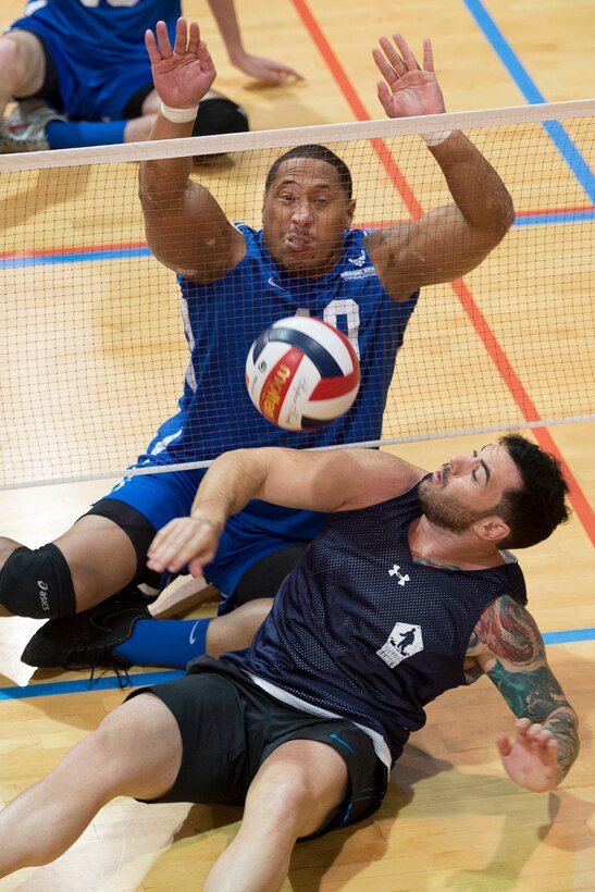Navy veteran Michael Roggio, front, and Air Force veteran Tino Uli battle at the net during a joint service sitting volleyball tournament for wounded warriors at the Pentagon, Nov. 19, 2015. DoD photo by EJ Hersom