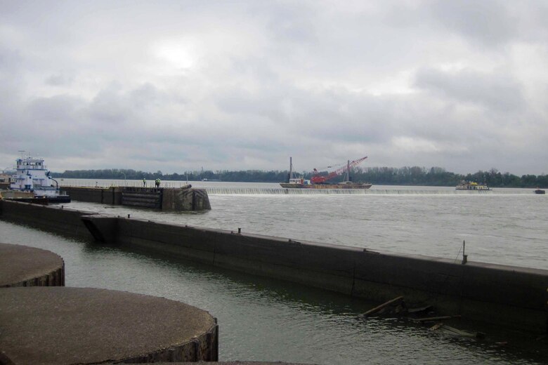 Members of the periodic inspection team look on as the workboat crew at Locks and Dam 52 lowers the wicket dam. Periodic inspections allow Corps engineers a chance to identify potential problems at civil works projects and to collaborate with project personnel to determine solutions.

                         