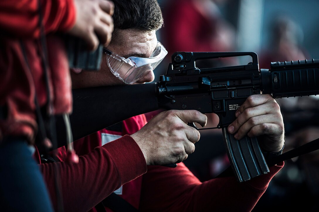 U.S. Navy Seaman Austin Perry fires an M16 assault rifle during a live-fire qualification exercise aboard the aircraft carrier USS Ronald Reagan in the waters south of Japan, Nov. 19, 2015. The carrier and its embarked air wing, Carrier Air Wing 5, provide a combat-ready force to protect and defend the collective maritime interests of the U.S. and its allies and partners in the Indo-Asia-Pacific region. U.S. Navy photo by Petty Officer 2nd Class Paolo Bayas