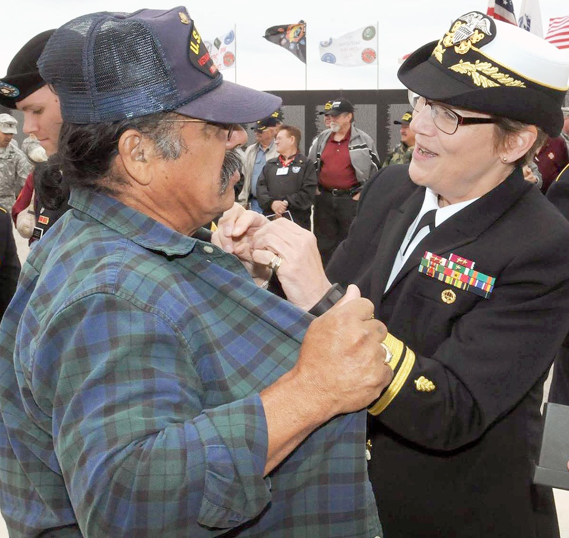 Navy Rear Adm. Rebecca McCormick-Boyle, commander of the Navy Medicine Education and Training Command at Fort Sam Houston, pins the Vietnam Veteran Lapel Pin on U.S. Navy Vietnam veterans during the “Salute To Veterans” event at MacArthur Field on Fort Sam Houston Friday, which honored veterans past and present for their service.