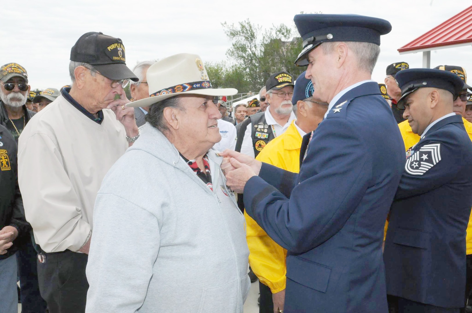 Air Force Lt. Gen. Darryl Roberson, commander of Air Education and Training Command, and AETC Command Chief Master Sgt. Gerardo Tapia, pin the Vietnam Veteran lapel pin on U.S Air Force Vietnam veterans during the “Salute To Veterans” event at MacArthur Field on Fort Sam Houston Friday, which honored veterans past and present for their service.