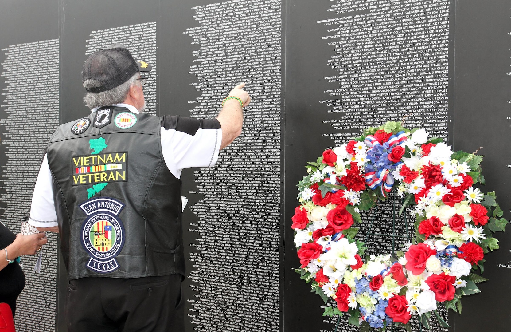 A Vietnam War veteran recognizes a name on the American Veteran Traveling Wall during the “Salute To Veterans” event at MacArthur Field on Fort Sam Houston Friday. Special recognition was given to those who fought during the Vietnam War. The backdrop presented during the ceremony is an 80 percent replica of the Vietnam Memorial Wall that travels through the country to commemorate those who fell during the Vietnam War. Although special recognition was given to Vietnam Veterans during the ceremony, all veterans were recognized and thanked for all they have given to the country with pride and honor.