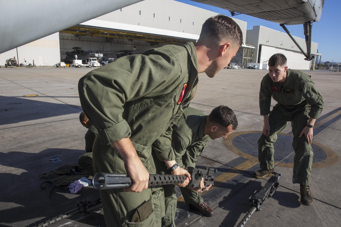 Marines with Marine Heavy Helicopter Squadron (HMH) 465 “Warhorse” stage .50 caliber machine guns near a CH-53E Super Stallion aboard Marine Corps Air Station Miramar, Calif., Nov. 16. Marines with HMH-465 will conduct aerial gun shoots, fire bucket training and terrain flights over the course of five days in El Centro, Calif. (U.S. Marine Corps photo by Sgt. Lillian Stephens/Released)