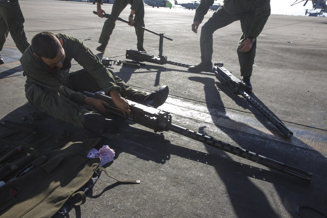 Lance Cpl. Joseph Marquez, a crew chief with Marine Heavy Helicopter Squadron (HMH) 465 “Warhorse” and a Vancouver, Wash. native, disassembles a .50-caliber machine gun aboard Marine Corps Air Station Miramar, Calif., Nov. 16. Marines with HMH-465 will conduct aerial gun shoots, fire bucket training and terrain flights over the course of five days in El Centro, Calif. (U.S. Marine Corps photo by Sgt. Lillian Stephens/Released)