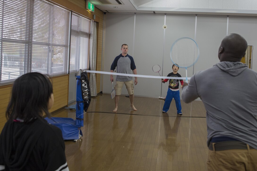 Petty Officer 2nd Class Jason McNeely, center, engineer with Headquarters and Headquarters Squadron, and Lance Cpl. Billy McNair, aviation ordnance technician with Marine Aviation Logistics Squadron 12, play racquetball during a Single Marine Program volunteer event at Kaihoku-En Children’s Home in Houfu City, Yamaguchi Prefecture, Japan, Nov. 14, 2015. The children and 18 volunteers played ping pong, racquetball, monkey in the middle, arm wrestled, colored books, played house and played the piano. The children interacted and built relationships with the 18 service members during the visit.