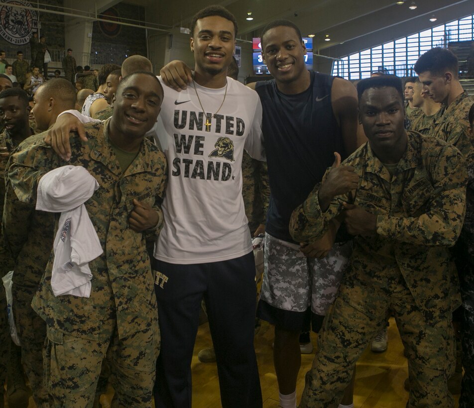 University of Pittsburg players pose with Marines after the 2015 Armed Forces Classic Nov. 14 at the Foster Fieldhouse aboard Camp Foster, Okinawa, Japan. Despite the game’s cancellation, the two teams chose to show their appreciation for the service members on a personal level. Players and coaches immersed themselves in the sea of woodland uniforms to thank the Marines for their hard work and sacrifices. Players posed for pictures, shook hands and even removed the jerseys off their backs to give to fans.