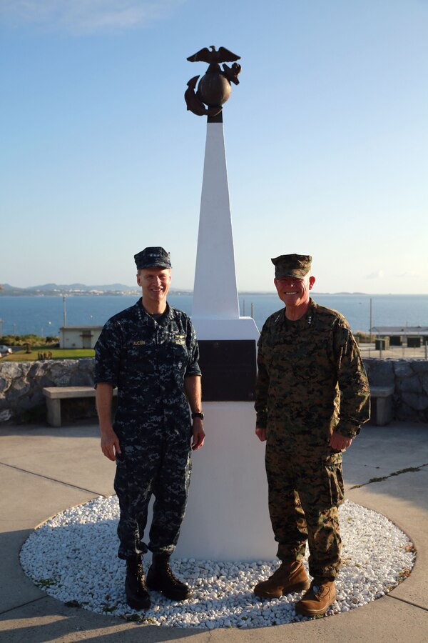 Lt. Gen. Larry D. Nicholson, the commanding general of III Marine Expeditionary Force, and Vice Adm. Joseph P. Aucoin, commander of the Navy's 7th Fleet, meet as the sun rises at the III MEF Headquarters Building, Camp Courtney, Okinawa, Japan, Nov. 20, 2015. Behind them stands a monument memorializing the Navy and Marine Corps' amphibious campaign in Okinawa during World War II. Today, the Navy and Marine Corps work with nations throughout the Pacific to promote enduring stability in the region.