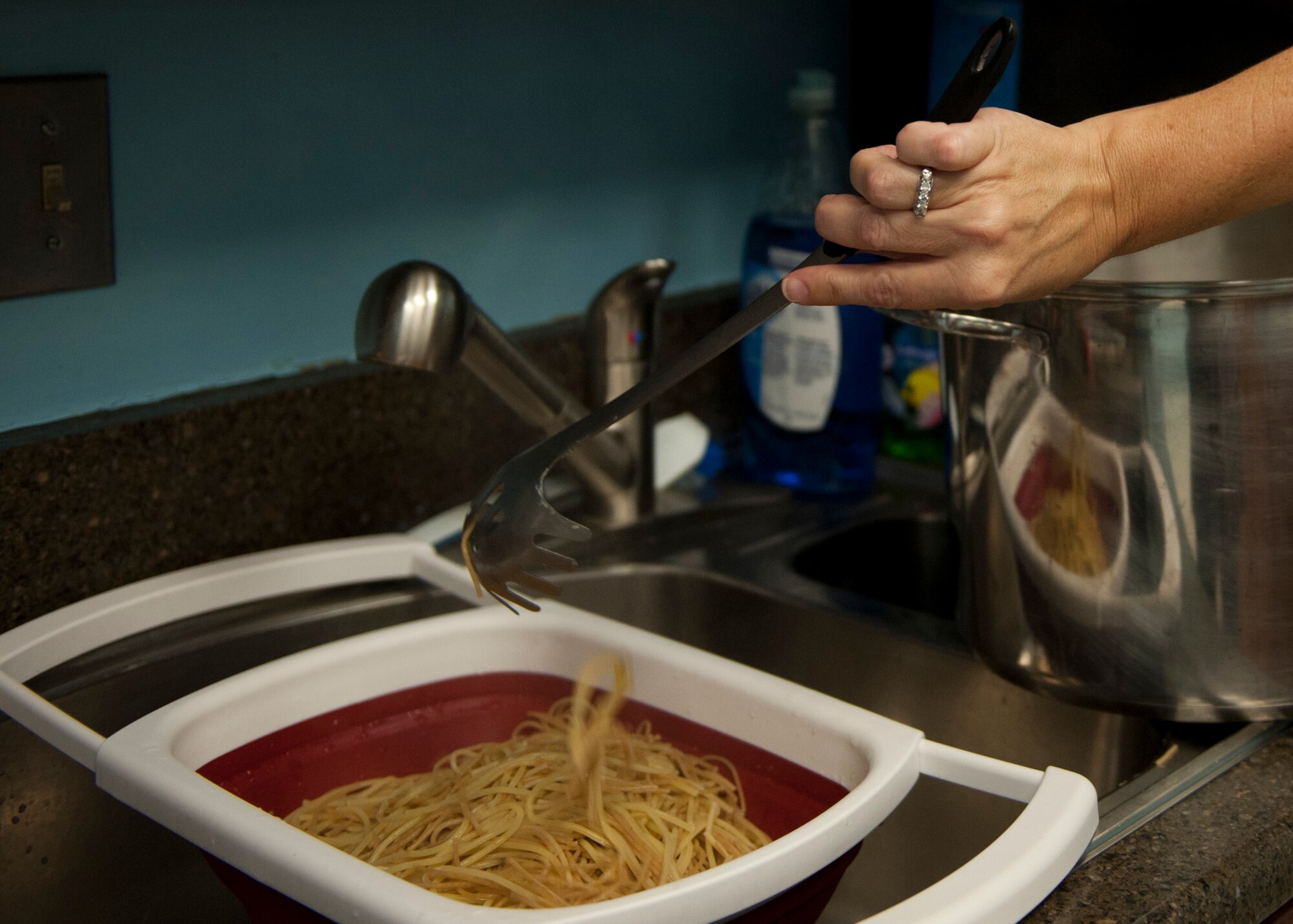 A volunteer strains spaghetti for a drive-thru family dinner at the base chapel, Nov. 17, 2015, at Moody Air Force Base, Ga. During the event, approximately 200 meals were prepared for deployed and remote assignment families, as well as Exceptional Family Member Program participants. (U.S. Air Force photo by Airman 1st Class Kathleen D. Bryant/Released)
