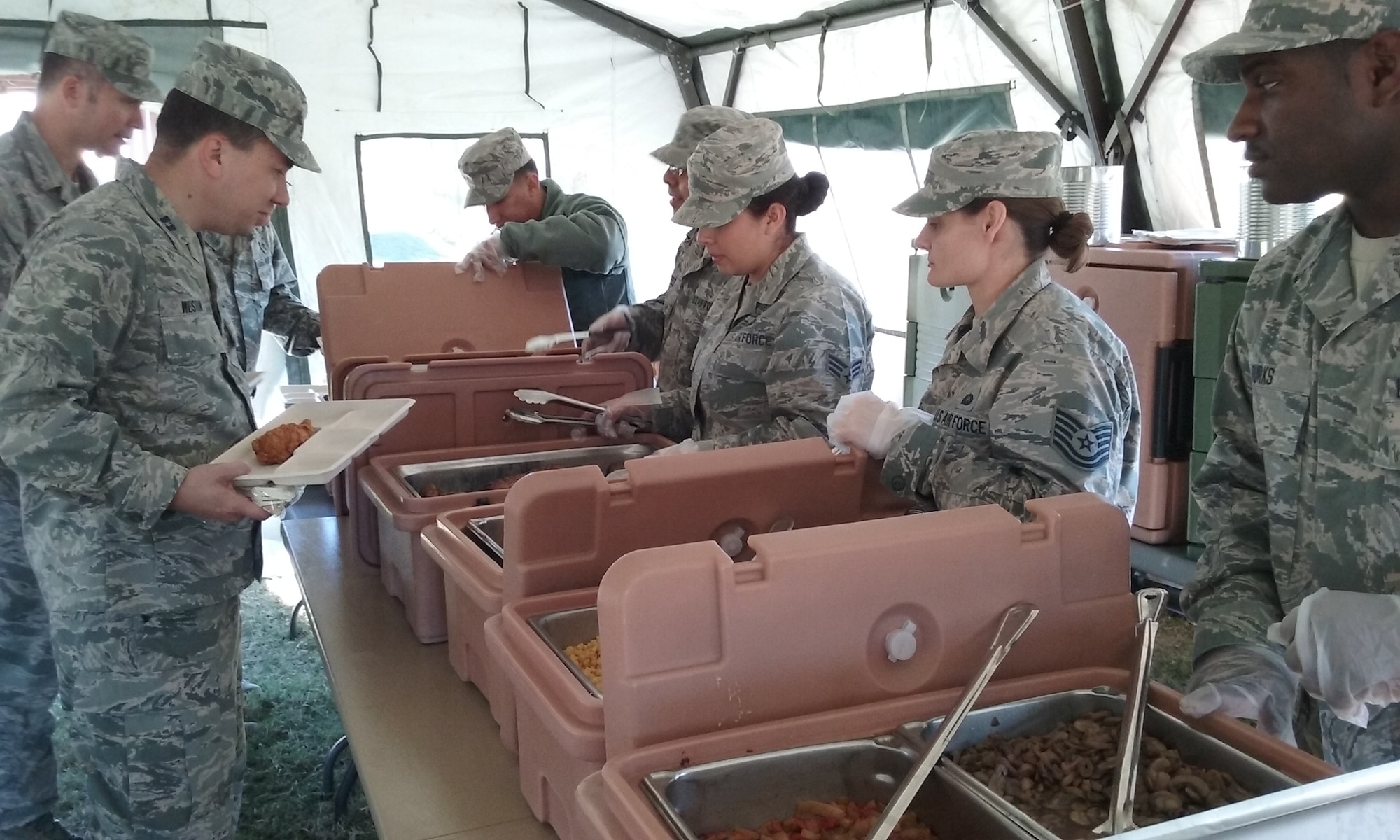 Airmen from the 507th Air Refueling Wing Force Support Squadron Services Sustainment Flight serve food to Ch. (Capt.) John Weston and Tech. Sgt. Patrick Garrison of 507th Air Refueling Wing Chapel Services during a field kitchen training exercise Nov. 7, 2015, at Tinker Air Force Base, Okla. The kitchen is designed to provide deployed personnel food at remote and undeveloped sites. (U.S. Air Force photo by Senior Airman Chelsea Thomas) 