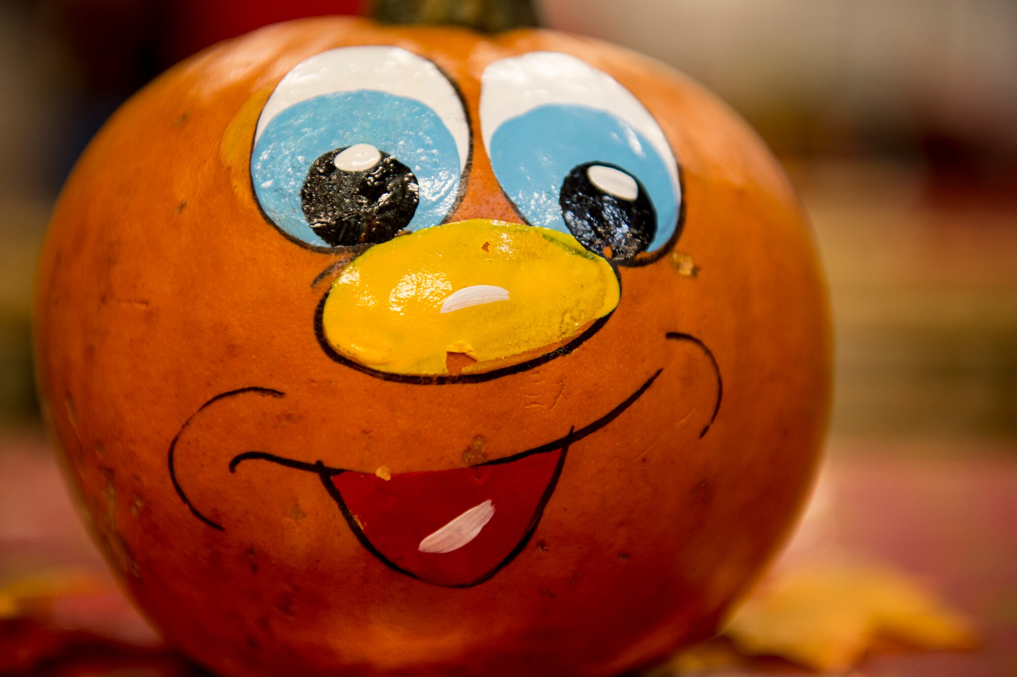 A pumpkin is displayed on a table during the Deployed Family Member Thanksgiving dinner, inside Fire Station 1 at Spangdahlem Air Base, Germany, Nov. 18, 2015.  Families ate a Thanksgiving meal while kids played inside a bouncy castle and interacted with Santa Claus at the event. (U.S. Air Force photo by Senior Airman Rusty Frank/Released)