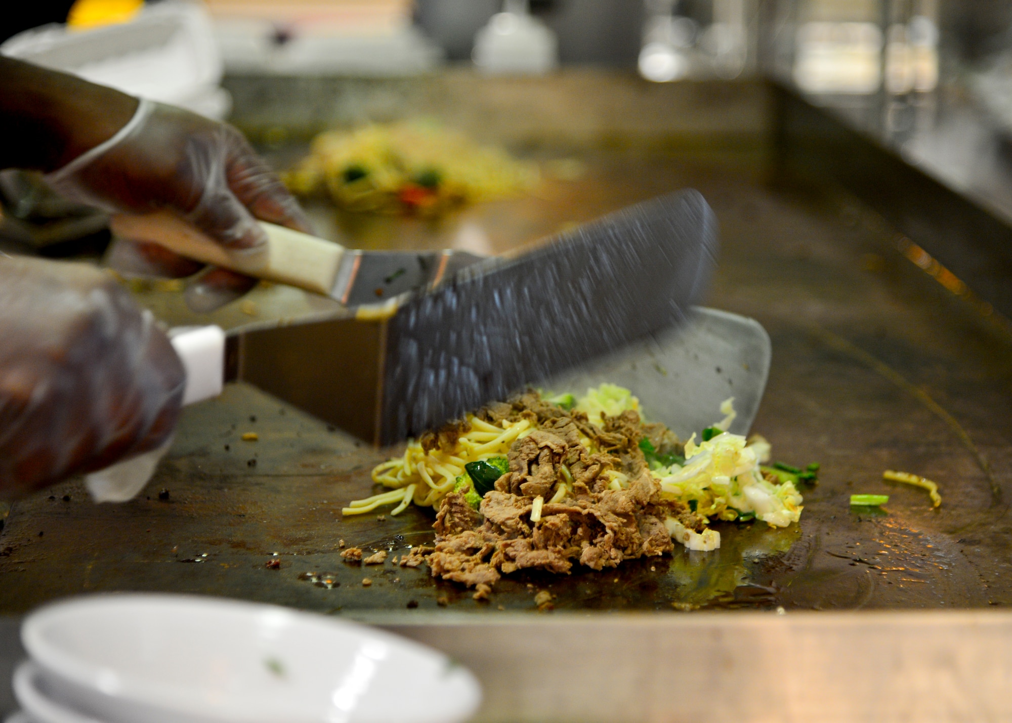 Tech. Sgt. Mark Obeng Duro, 436th Force Support Squadron food service section chief, prepares Mongolian style food during the soft opening of the Patterson Dining Facility Nov. 17, 2015, at Dover Air Force Base, Del. Airmen working in the dining facility were trained by professional culinary chefs while the dining facility underwent renovations and improvements from the Air Force Food Transformation Initiative. (U.S. Air Force photo/Senior Airman William Johnson)