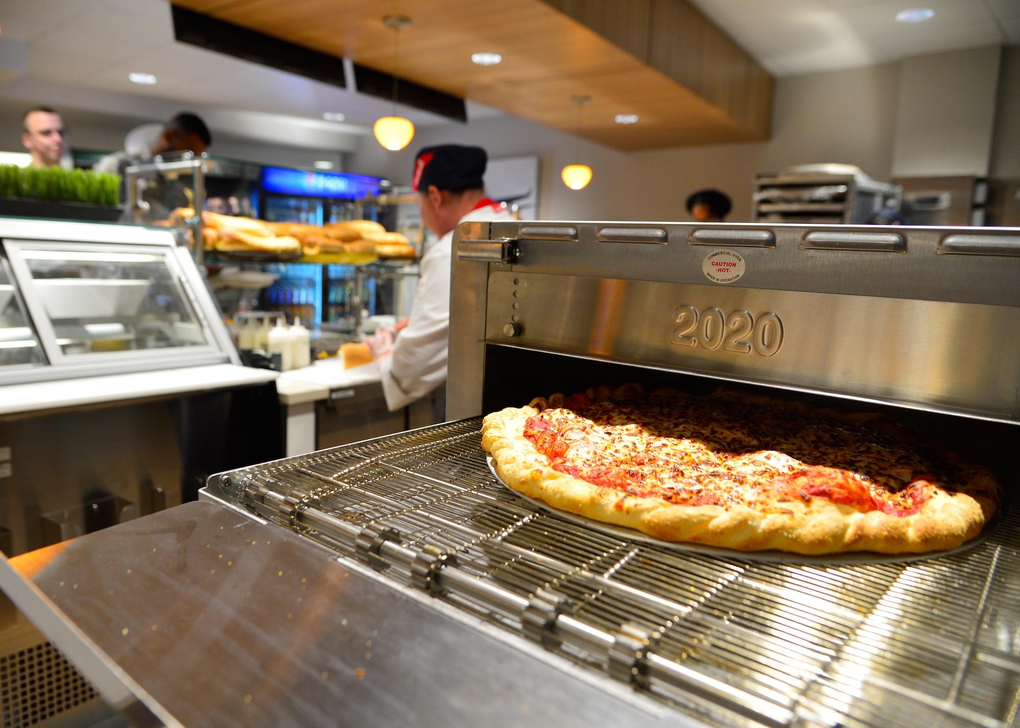 A fresh pizza comes out of an oven during the soft opening of the Patterson Dining Facility Nov. 17, 2015, at Dover Air Force Base, Del. The Patterson Dining Facility closed for renovations under the Air Force Food Transformation Initiative. (U.S. Air Force photo/Senior Airman William Johnson) 