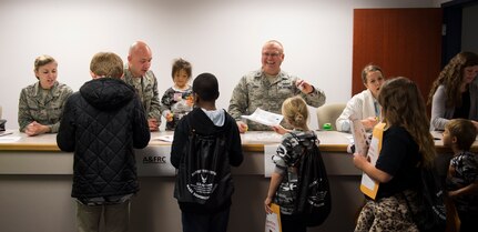 Joint Base Charleston members and volunteers simulate a deployment line with children participating in a mock deployment line event November 14, 2015, at the 628th Logistics Readiness Squadron on JB Charleston – Air Base, S.C. The event was held to give children a glimpse into what it’s like for their parents to prepare for a deployment. During the event, children transitioned through a mock processing line where they spoke to several base agencies including the chapel, medical, finance, Airman and Family Readiness Center, base leadership and more. (U.S. Air Force photo/Airman 1st Class Clayton Cupit)