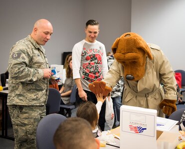 McGruff the crime dog high fives with children participating in a mock deployment line event November 14, 2015, in a classroom at the 628th Logistics Readiness Squadron on JB Charleston – Air Base, S.C. The event was held to give children a glimpse into what it’s like for their parents to prepare for a deployment. During the event, children transitioned through a mock processing line where they spoke to several base agencies including the chapel, medical, finance, Airman and Family Readiness Center, base leadership and more. (U.S. Air Force photo/Airman 1st Class Clayton Cupit)