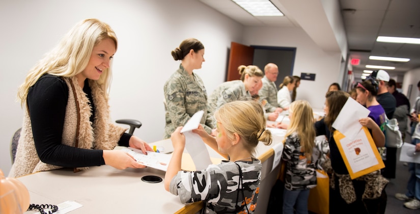 Joint Base Charleston members and volunteers simulate a deployment line with children participating in a mock deployment line event November 14, 2015, at the 628th Logistics Readiness Squadron on JB Charleston – Air Base, S.C. The event was held to give children a glimpse into what it’s like for their parents to prepare for a deployment. During the event, children transitioned through a mock processing line where they spoke to several base agencies including the chapel, medical, finance, Airman and Family Readiness Center, base leadership and more. (U.S. Air Force photo/Airman 1st Class Clayton Cupit)