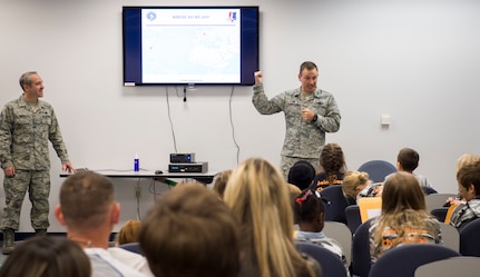 Col. John Lamontagne, 437th Airlift Wing commander, talks about a deployment scenario with children during a mock deployment line event November 14, 2015, at the 628th Logistics Readiness Squadron on JB Charleston – Air Base, S.C. The event was held to give children a glimpse into what it’s like for their parents to prepare for a deployment. During the event, children transitioned through a mock processing line where they spoke to several base agencies including the chapel, medical, finance, Airman and Family Readiness Center, base leadership and more. (U.S. Air Force photo/Airman 1st Class Clayton Cupit)
