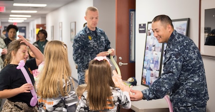 Sailors from Joint Base Charleston interact with children participating in a mock deployment line event by crafting balloon animals for them November 14, 2015, at the 628th Logistics Readiness Squadron on JB Charleston – Air Base, S.C. The event was held to give children a glimpse into what it’s like for their parents to prepare for a deployment. The children transitioned through a mock processing line where they spoke to several base agencies including the chapel, medical, finance, Airman and Family Readiness Center, base leadership and more. (U.S. Air Force photo/Airman 1st Class Clayton Cupit)
