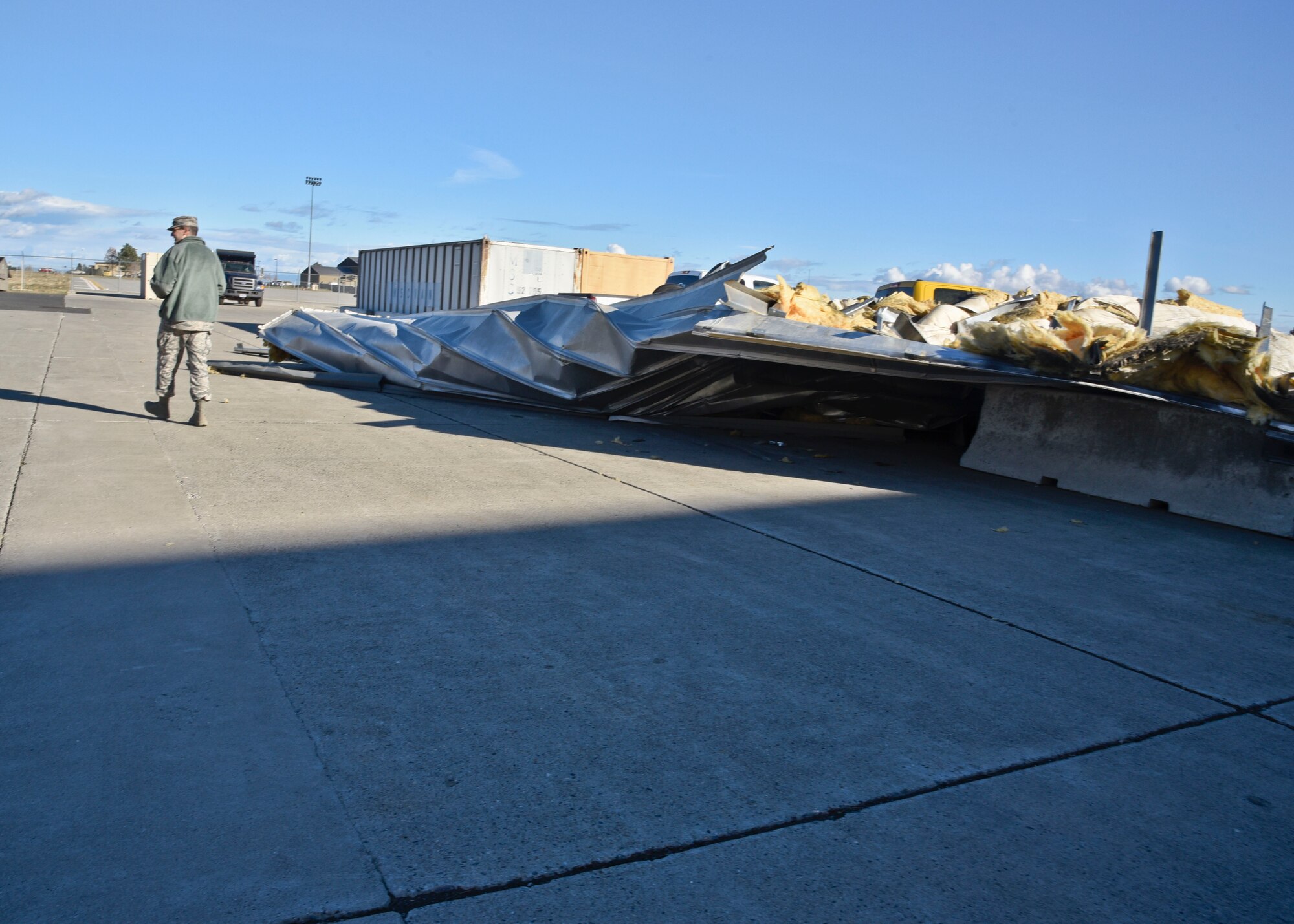 Airman 1st Class Nicolo Daniello, 92nd Air Refueling Wing public affairs photojournalist, documents the damage done to vehicles Nov. 18, 2015 after parts of roofing from the snow barn blew off during a large windstorm at Fairchild Air Force Base, Wash. The windstorm was the largest Fairchild has experienced since 1941, causing a majority of the base to lose power. The storm blew over trees and partial parts of buildings causing damage to rooftops, government and personal operated vehicles and power outages on base. (U.S. Air Force Photo/Airman 1st Class Taylor Bourgeous)
