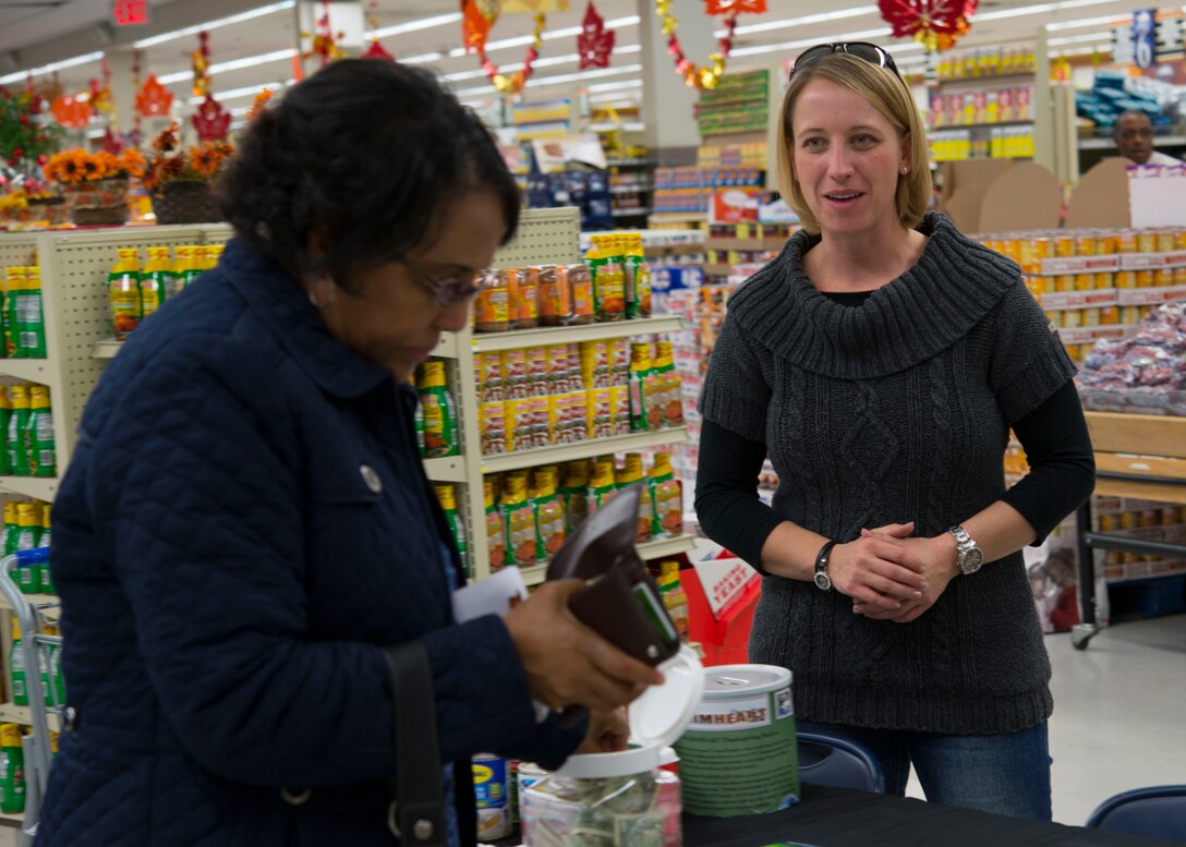 U.S. Air Force Tech. Sgt. Nicole, a geographical-integrations and testing noncommissioned officer in charge assigned to the 497th Operation Support Squadron, collects donations for the Operation Warmheart Thanksgiving Basket Drive from a Commissary patron at Langley Air Force Base, Va., Nov. 16, 2015. The Thanksgiving baskets include all the traditional staples of a Thanksgiving meal such as, potatoes, cranberry sauce and stuffing. (U.S. Air Force photo by Staff Sgt. J.D. Strong II)