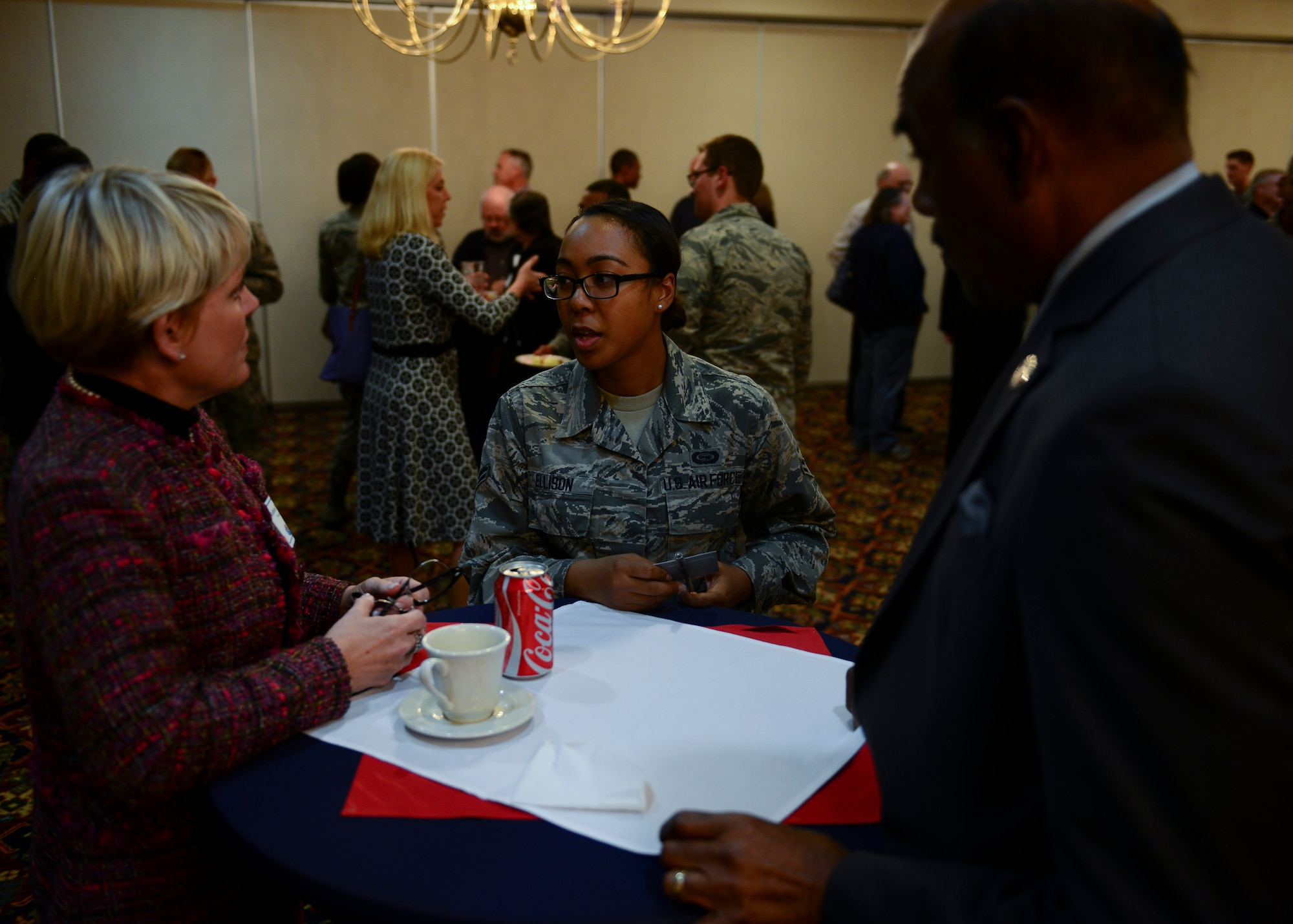 U.S. Air Force Airman 1st Class Shannon, a geospatial intelligence analyst assigned to the 45th Intelligence Squadron, Robin Bledsoe, left and Mayor of Hampton George Wallace, speak during the “Adopt and Airman” program reception at Langley Air Force Base, Va., Nov. 16, 2015. During the function, the Airmen and families met for the first time to put a face with a name. (U.S. Air Force photo by Staff Sgt. Ciara Gosier)