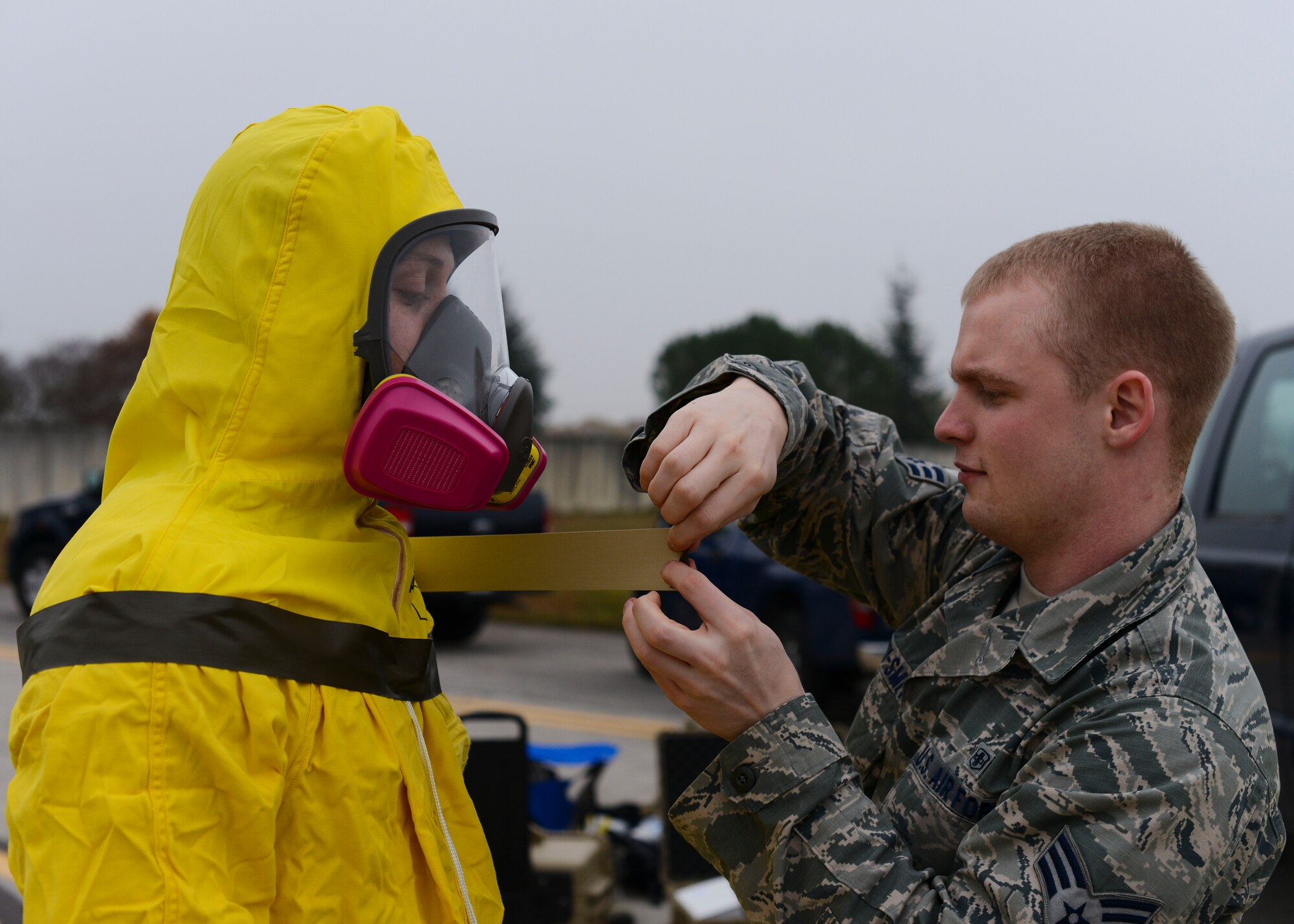 U.S. Air Force Senior Airman Patrick Kenny-Smith, 31st Aerospace Medicine Squadron bioenvironmental engineering journeyman, seals an Airman’s containment suit during a wing inspection, Nov. 17, 2015, at Aviano Air Base, Italy. The 31st Fighter Wing conducts in several inspections annually designed to identify and rectify deficiencies while highlighting best practices and outstanding performers. (U.S. Air Force photo by Senior Airman Austin Harvill/Released)