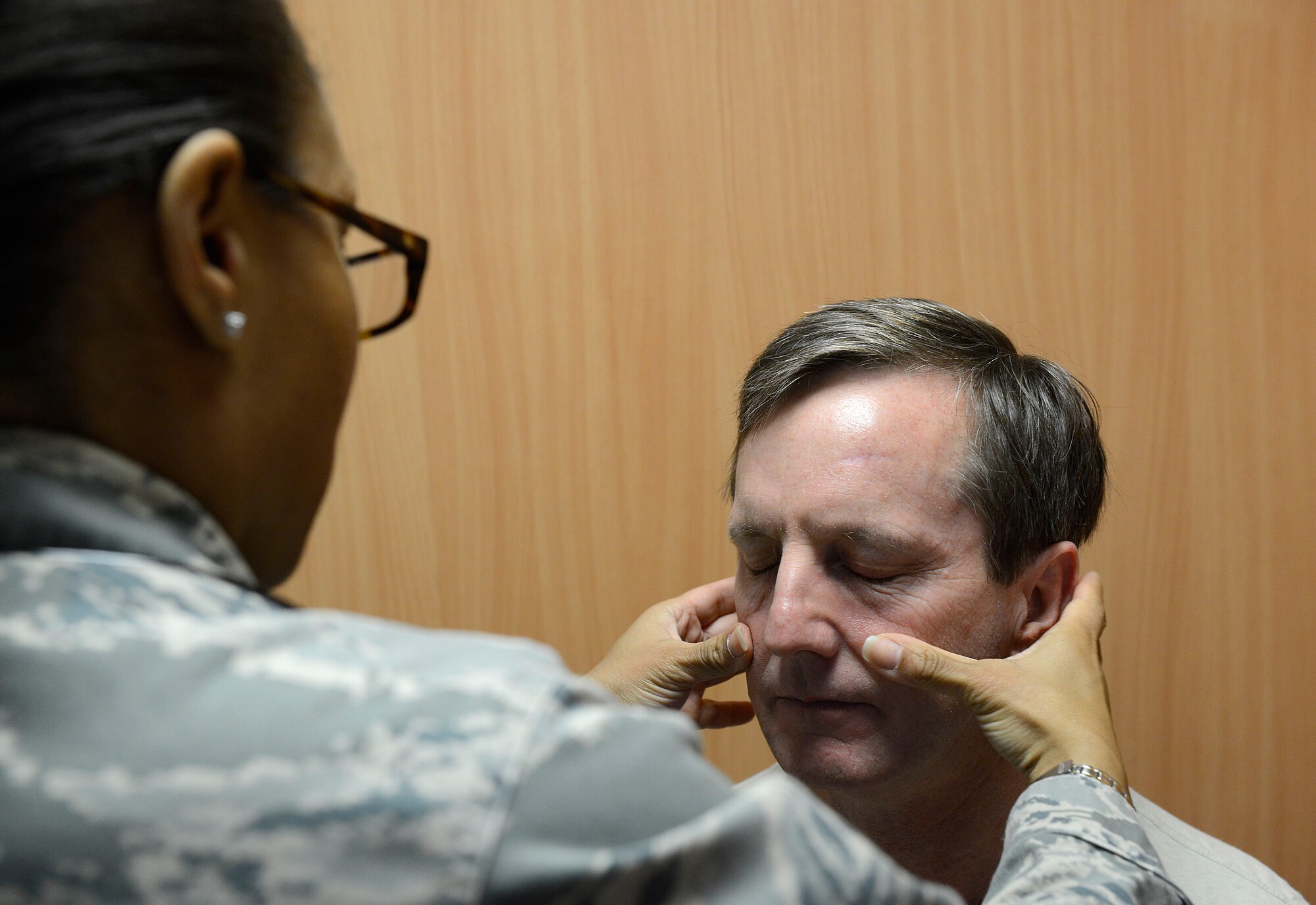 Maj. Courtney Wallace, Family Health Clinic clinical nurse, feels for signs of inflammation for Col. James Stephenson, 86th Medical Operations Squadron commander, at the Cold and Allergy Clinic at Ramstein Air Base, Germany, Nov. 4, 2015. Patients suffering from cough, congestion, runny nose, itchy eyes or other such symptoms can now be seen by a doctor much sooner than they had been able to prior to the opening of the new clinic. (U.S. Air Force photo/Airman 1st Class Tryphena Mayhugh) 