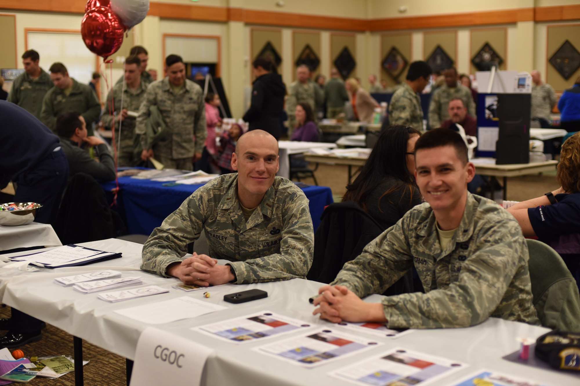 2nd Lt. Nathan Spradley, 741st Missile Security Forces Squadron officer in charge of security escort teams, left, poses for a photograph with 1st Lt. Christopher Gresham, 741st MSFS section commander, at their Company Grade Officer Club information table during a base fair held at the Malmstrom Air Force Base Grizzly Bend Nov. 18, 2015. In total, 36 organizations from around the base gathered to support the event. (U.S. Air Force photo/Airman Collin Schmidt)