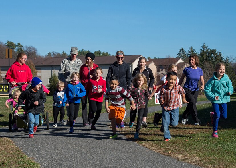 Military families take off running at the Family 2K Fun Run on base Nov. 18 during a Month of the Military Family activity. Month of the Military Family, celebrated each November, is held annually to recognize sacrifices and contributions made by every member of the military family. (U.S. Air Force photo by Mark Herlihy)