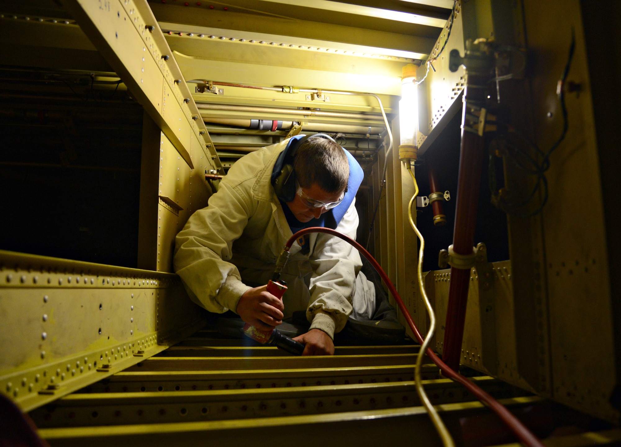 Shannon Low, a sheetmetal mechanic with the 566th Aircraft Maintenance Squadron, works inside the cramped space inside the wing’s fuel cell.  (Air Force photo by Kelly White/Released)
