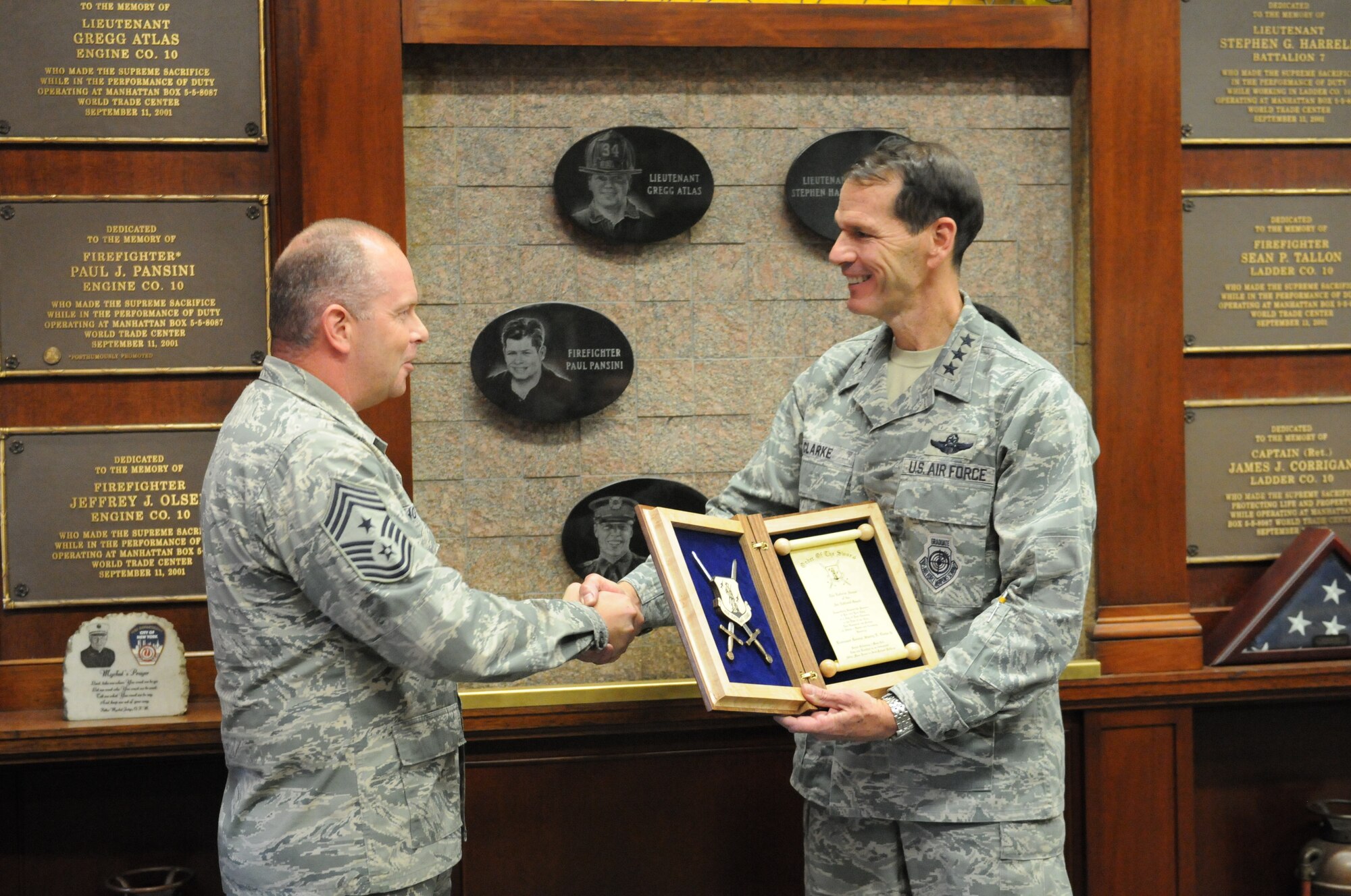 U.S. Air Force Lt. Gen. Stanley E. Clarke, III, director, Air National Guard, is presented the Order of the Sword invitation from Chief Master Sgt. James W. Hotaling, command chief master sergeant of the Air National Guard, at 10 House Fire Department, New York, N.Y., Nov. 11, 2015. The Air Force enlisted corps established the Order of the Sword to recognize and honor military senior officers for significant contributions to the enlisted force. (Air National Guard photo by Master Sgt. David Eichaker/released)