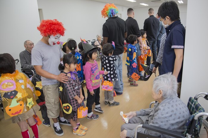 Service members from Marine Corps Air Station Iwakuni, Japan, and Japanese children from Ekimae Hoikuen Pre-school visited the Vita Nursing Home in Iwakuni City, Oct. 27, 2015. The community relations event, hosted by the Marine Memorial Chapel on the air station, gave service members the opportunity to interact with the Japanese youth and teach them about Halloween. The children also recited the American and Japanese alphabets with the senior citizens at the nursing home.