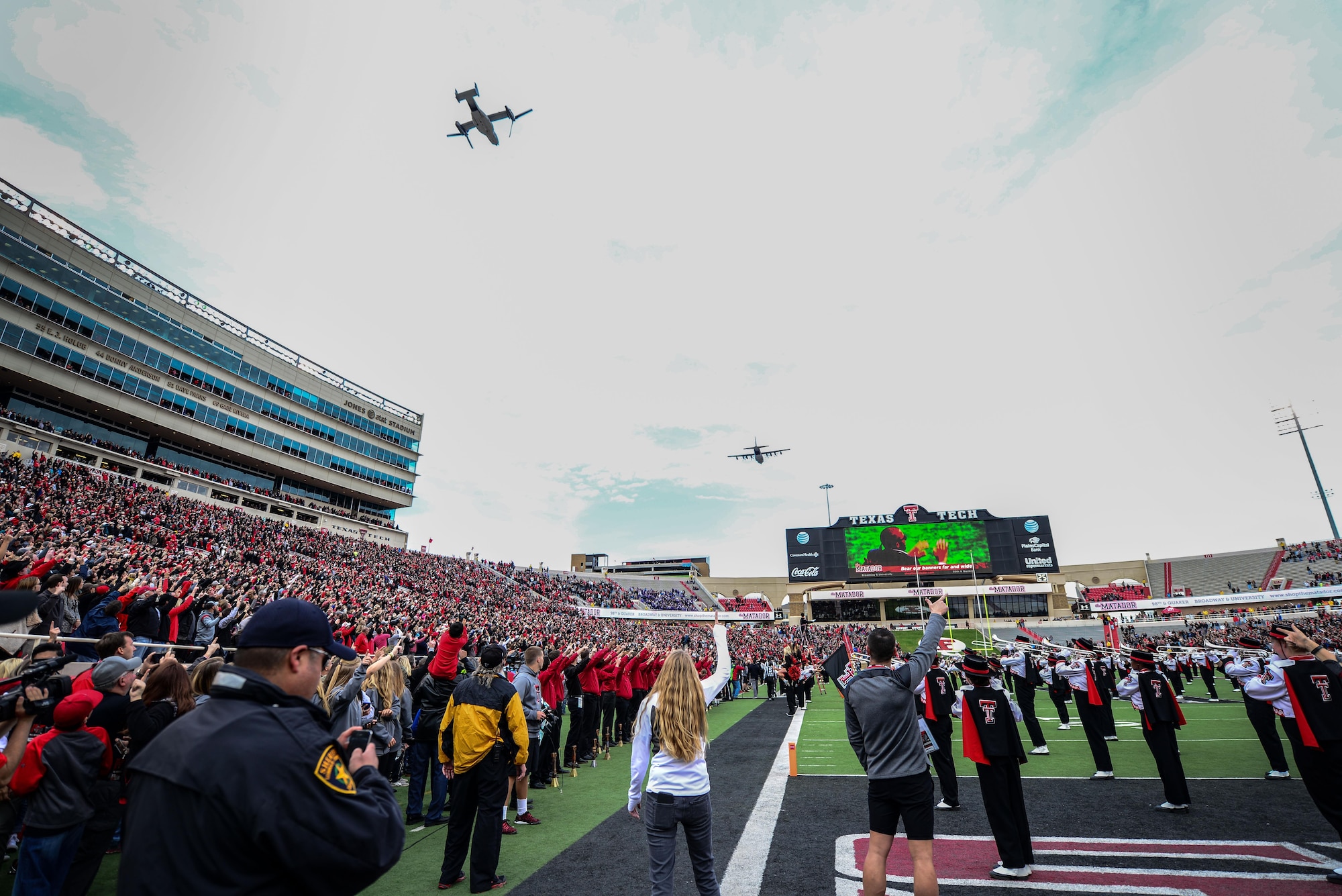 An MC-130J Commando II and CV-22 Osprey fly over Jones AT&T Stadium as Texas Tech fans play and sing “The Matador Song” Nov. 14, 2015, in Lubbock, Texas. The flyover kicked off Tech’s “Celebrating America” appreciation game marking the school’s gratitude and respect for military and first responders. (U.S. Air Force photo/Airman 1st Class Shelby Kay-Fantozzi) 