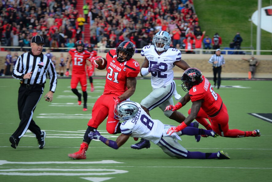 Texas Tech running back Deandre Washington breaks through an attempted tackle by Kansas State University defensive back Duke Shelley and linebacker Charmeachealle Moore to run an 80-yard touchdown Nov. 14, 2015, in Lubbock, Texas. The TTU home game against Kansas State was their “Celebrating America” appreciation game, marking the school’s gratitude and respect for military and first responders. (U.S. Air Force photo/Airman 1st Class Shelby Kay-Fantozzi) 