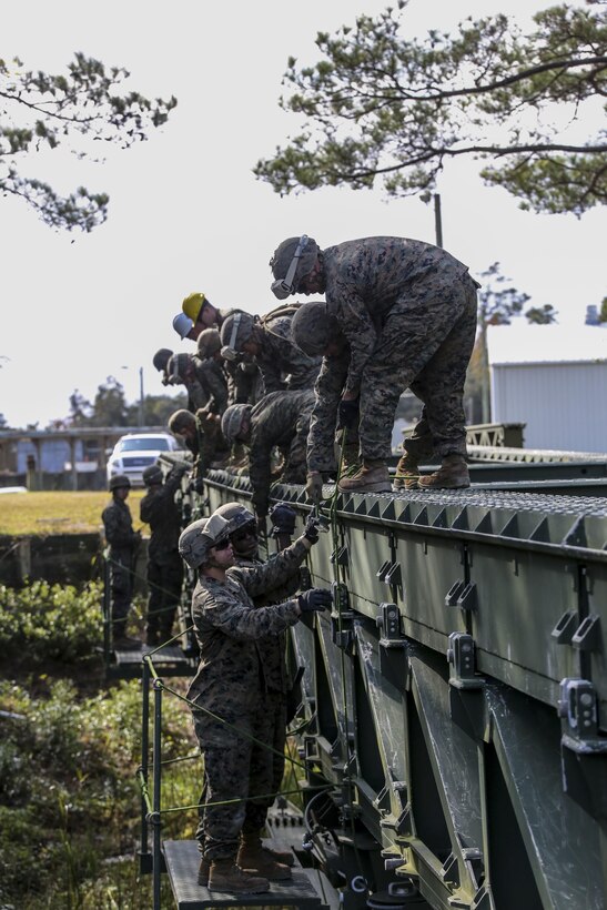 Marine students attending the 8th Engineer Support Battalion Medium Girder Bridge Master’s Course conduct the link reinforcement process during a field exercise at Camp Lejeune, N.C., Nov. 18, 2015. Link reinforcement requires additional bridge parts to make the bridge more stable. (U.S. Marine Corps photo by Cpl. Paul S. Martinez/Released)