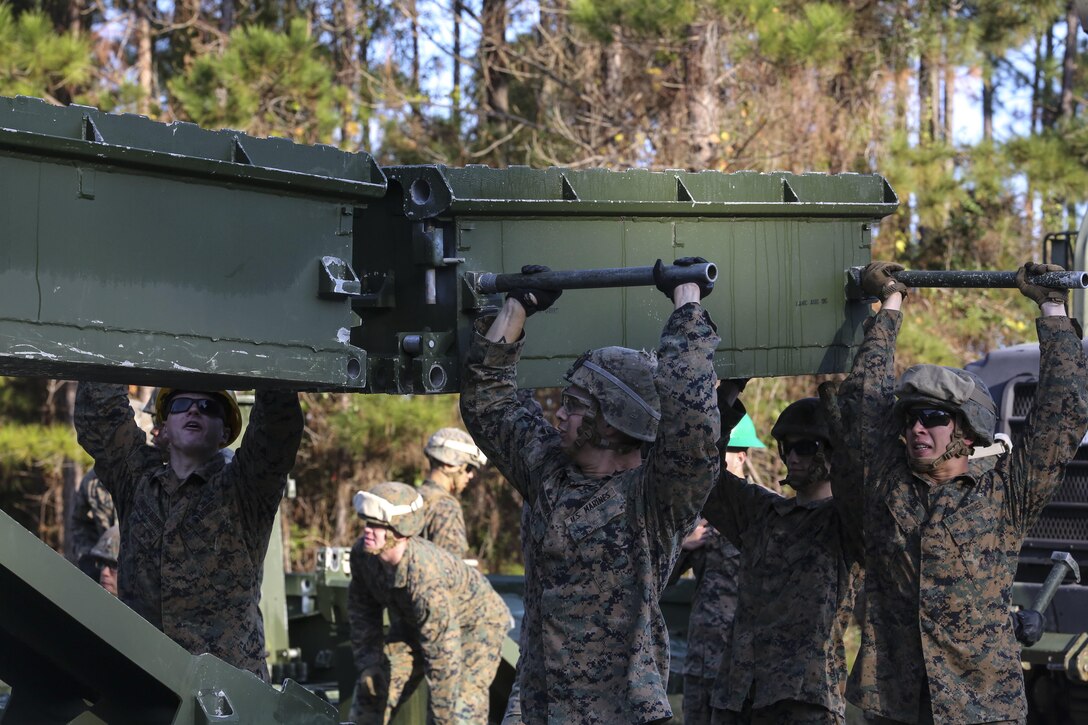 Marine students attending the 8th Engineer Support Battalion Medium Girder Bridge Master’s Course lift a bridge part during a field exercise at Camp Lejeune, N.C., Nov. 18, 2015. The course, now in its final week, teaches Marines to lead the bridge building process, and is hosting Marines from 9th Engineer Support Battalion, 3rd Marine Logistics Group, based at Camp Hansen, Okinawa, Japan. (U.S. Marine Corps photo by Cpl. Paul S. Martinez/Released)