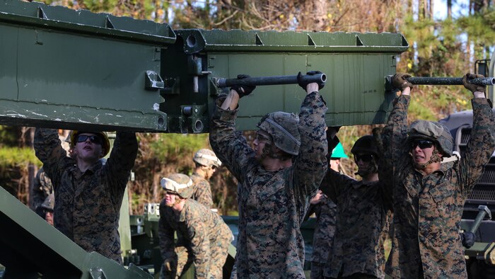 Marine students attending the 8th Engineer Support Battalion Medium Girder Bridge Master’s Course lift a bridge part during a field exercise at Marine Corps Base Camp Lejeune, North Carolina, Nov. 18, 2015. The course, now in its final week, teaches Marines to lead the bridge building process, and is hosting Marines from 9th Engineer Support Battalion, 3rd Marine Logistics Group, based at Marine Corps Base Camp Hansen, Okinawa, Japan. 