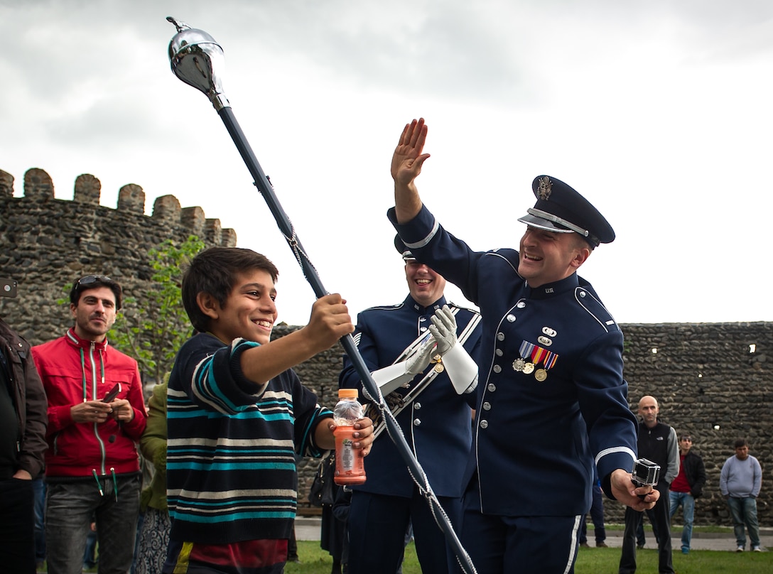 First Lt. Justin Lewis, the U.S. Air Forces in Europe Band flight commander, dances with a child during a marching band performance in Kvareli, Georgia, Oct. 18, 2015. From Oct. 15-19, 33 bandsmen from the U.S. Air Forces in Europe Band traveled to the Republic of Georgia for several events, including performing in the First International Military Bands Festival in Tbilisi. This is the first time in nearly 10 years that the USAFE Band has traveled to conduct a mission in Georgia. Georgia and the U.S. are military partners and engagements like these help to further strengthen the bonds between the two nations. (U.S. Air Force photo/ Tech. Sgt. Ryan Crane)