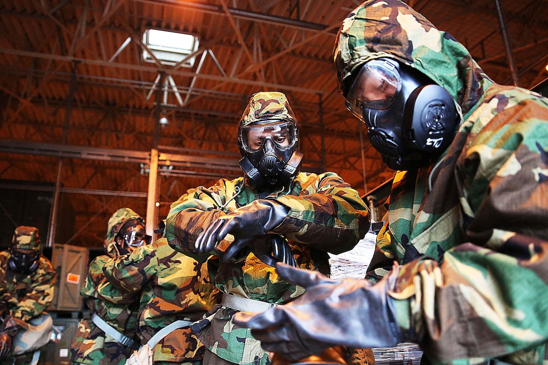 U.S. Marines don mission-oriented protective gear during a simulated chemical attack at Marine Corps Air Station Iwakuni, Japan, Nov. 18, 2015. This decontamination exercise focuses on chemical, biological, radiological and nuclear defense training to enable combat proactivity and readiness. U.S. Marine Corps photo by Cpl. Jessica Quezada    