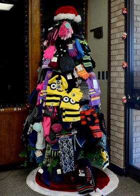 A Christmas tree is covered in gloves, hats and scarves during the Mitten Tree kick off, Nov. 17, 2015 Altus Air Force Base, Okla. The Mitten Tree program has been providing children of Altus with warm clothes for over 40 years during the winter holiday season. (U.S. Air Force photo by Airman 1st Class Nathan Clark/Released)
